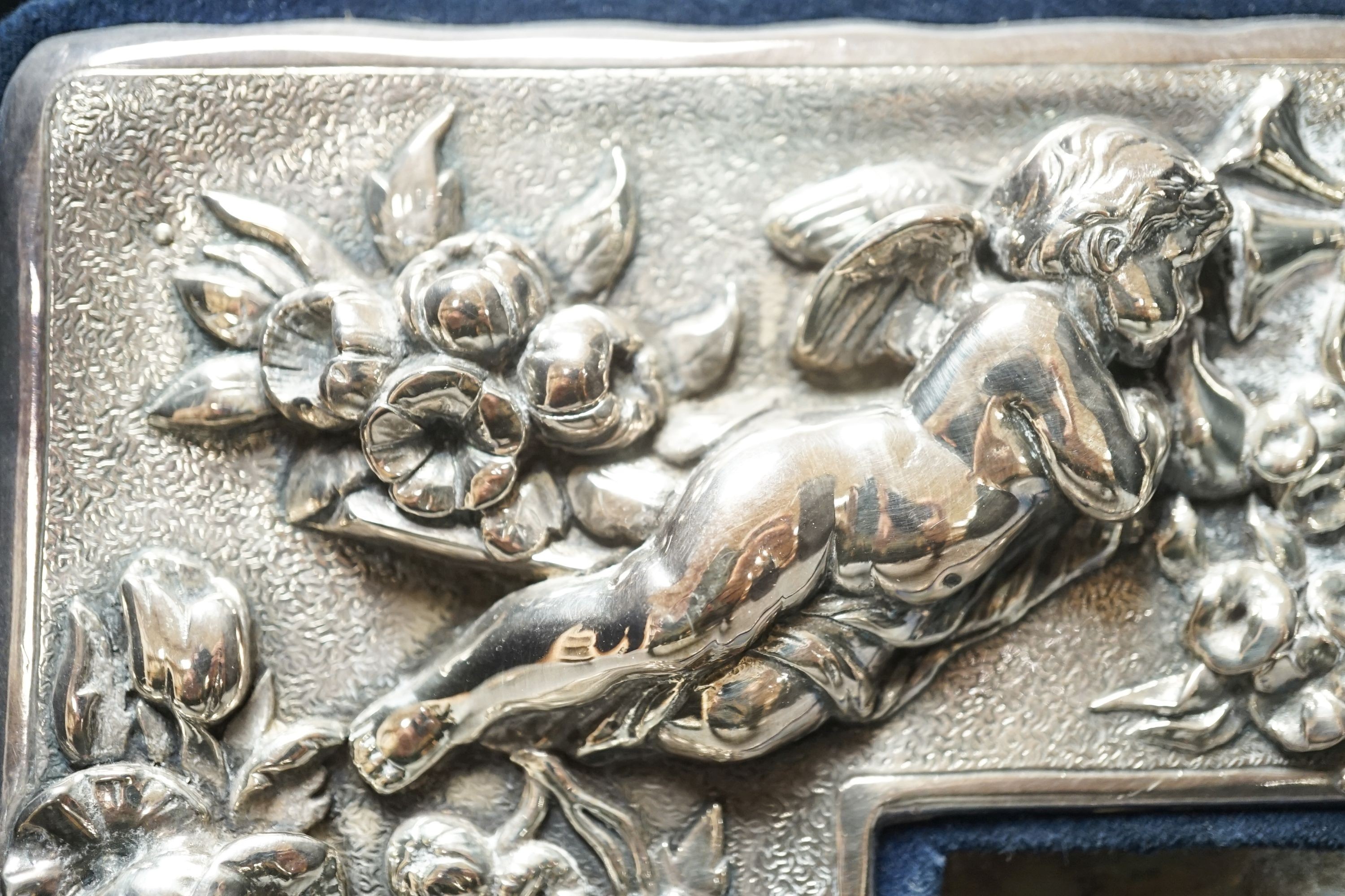 A modern sterling mounted photograph frame boldly embossed with cherubs, width 27.2cm.